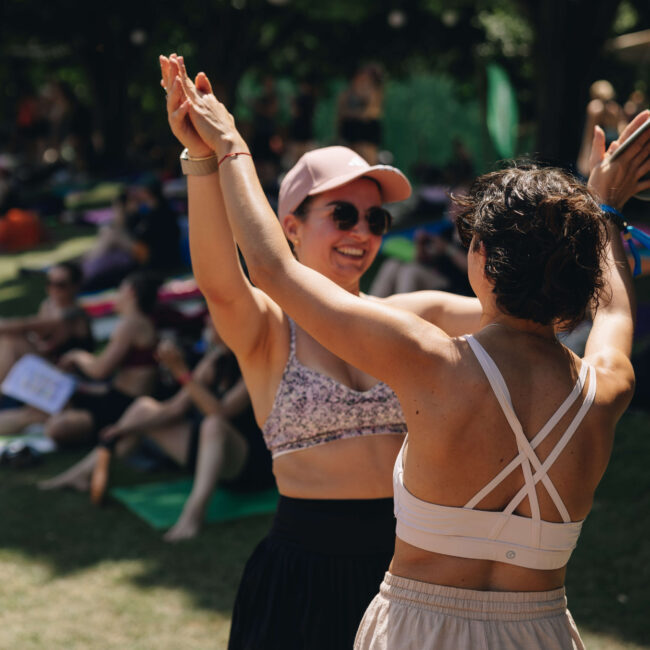 Zwei Frauen geben sich lachend ein High Five beim Feel Good Festival